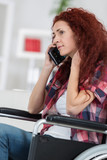confident woman in wheelchair with her mobile phone