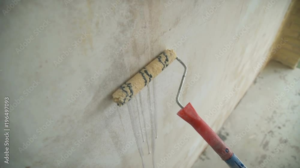 A man painting a wall. Repair in the apartment A man painting a wall. Repair in the apartment