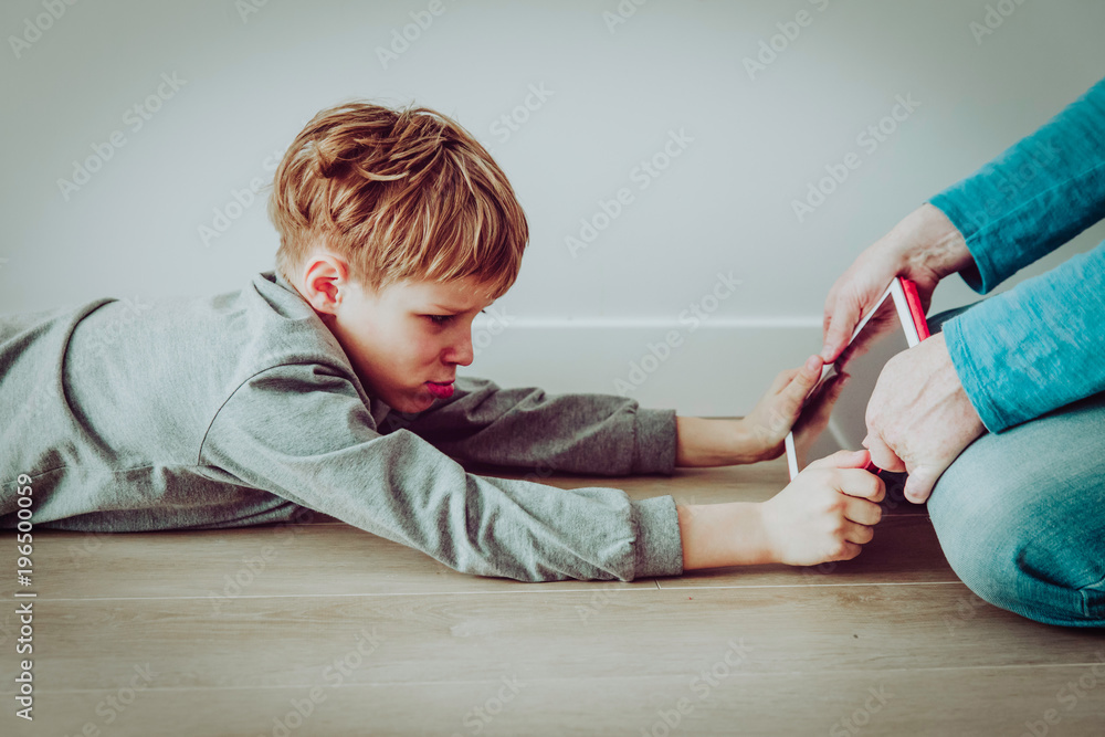 Naklejka premium computer addiction- father taking touch pad from angry child