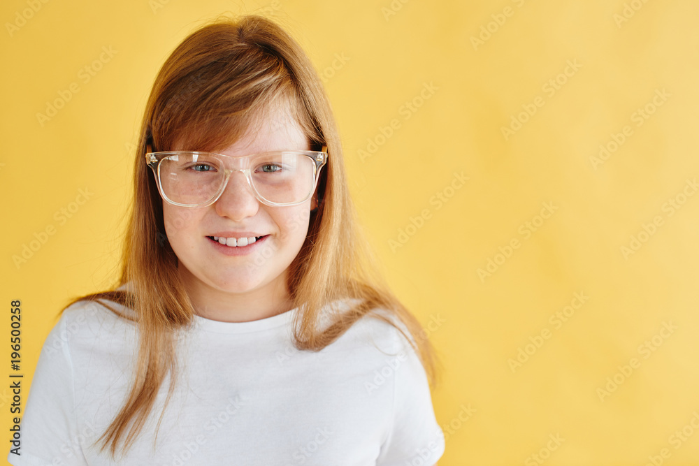 portrait of redhead teen girl on yellow background