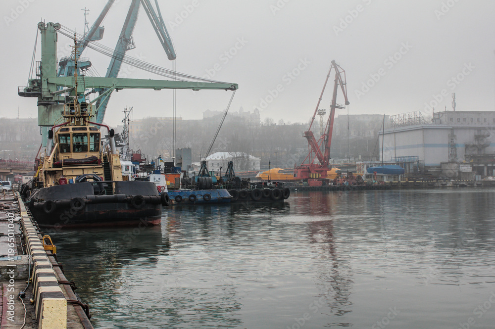 Sea cargo port. Tug, floating crane, dry cargo ship and other infrastructure of the port.