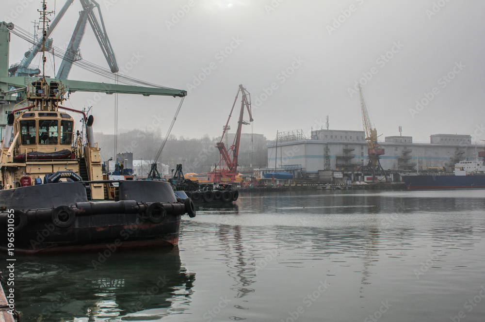 Sea cargo port. Tug, floating crane, dry cargo ship and other infrastructure of the port.