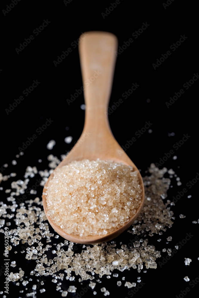 Brown sugar in wood spoon on black background.Components of The food is sweet delicious. Brown sugar in wood spoon on black background.Components of The food is sweet delicious.