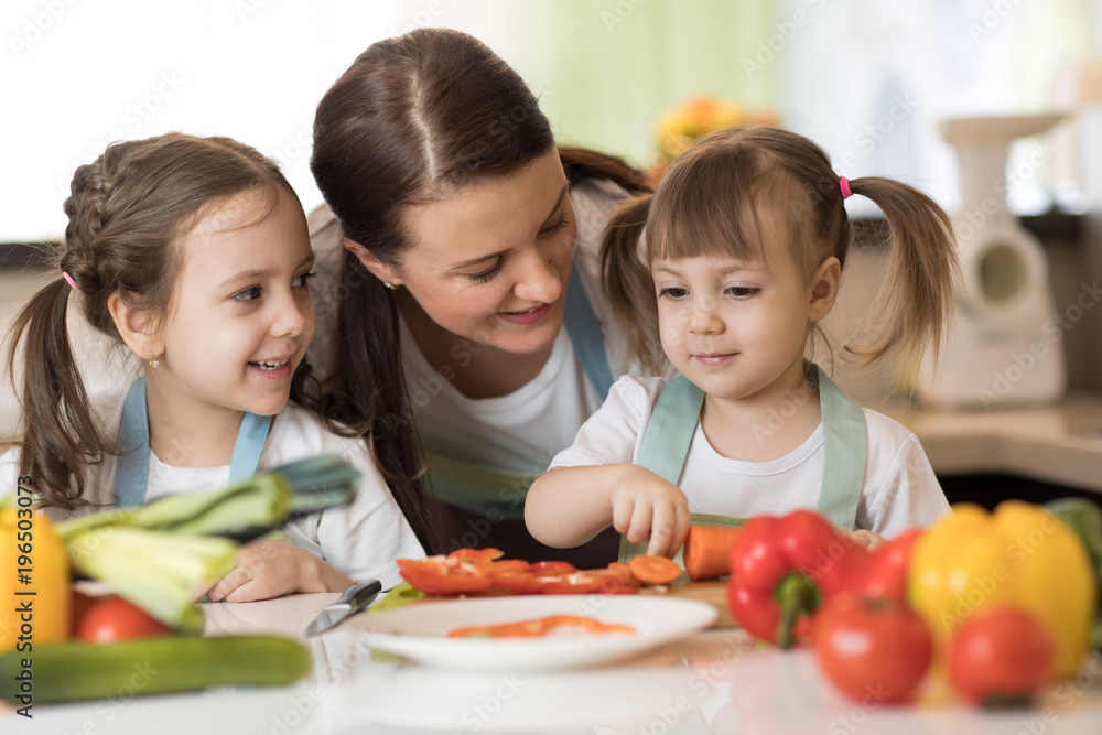 Happy mother and her kids daughters enjoy making healthy meal together Happy mother and her kids daughters enjoy making healthy meal together