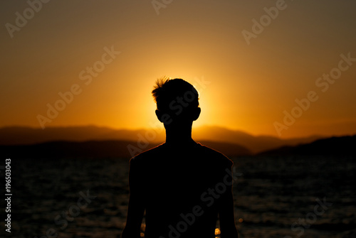 Fascination of silhouette of young boy on sunset