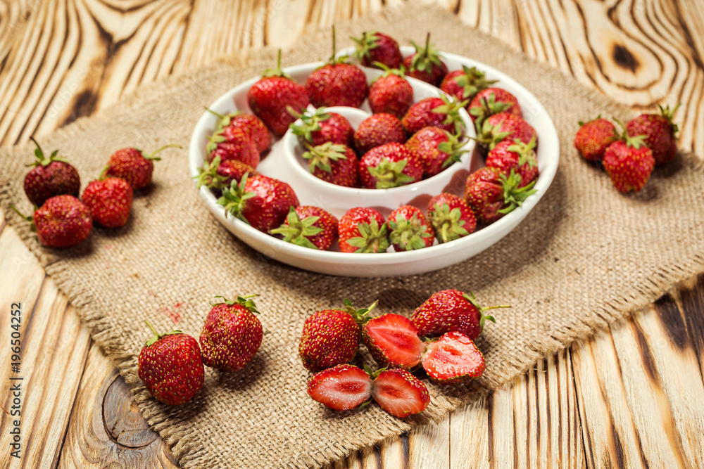 red strawberries in bowl on a wooden background red strawberries in bowl on a wooden background