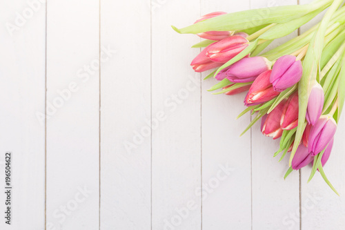 Bunte Frühlingsblumen auf einem Holztisch im Gegenlicht