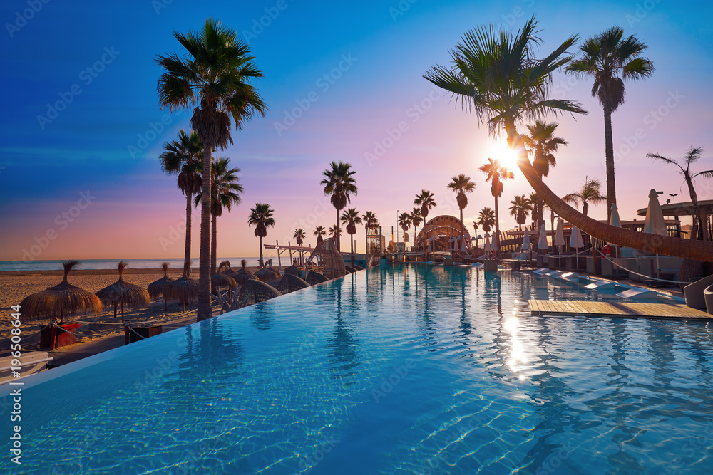 Resort pool in a beach with palm trees sunrise Resort pool in a beach with palm trees sunrise