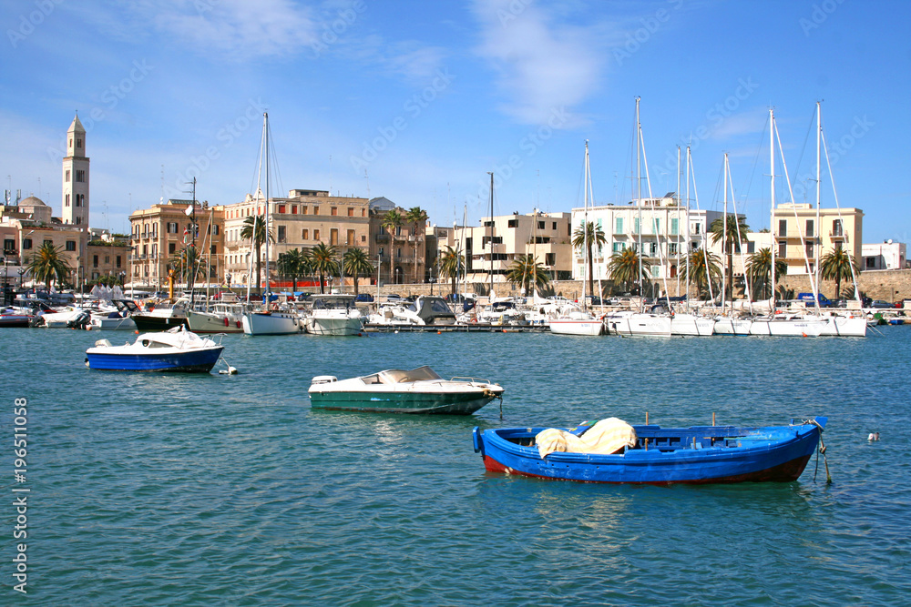 Panorama of Bari old town with the bell tower of the cathedral and the blue sea with boats