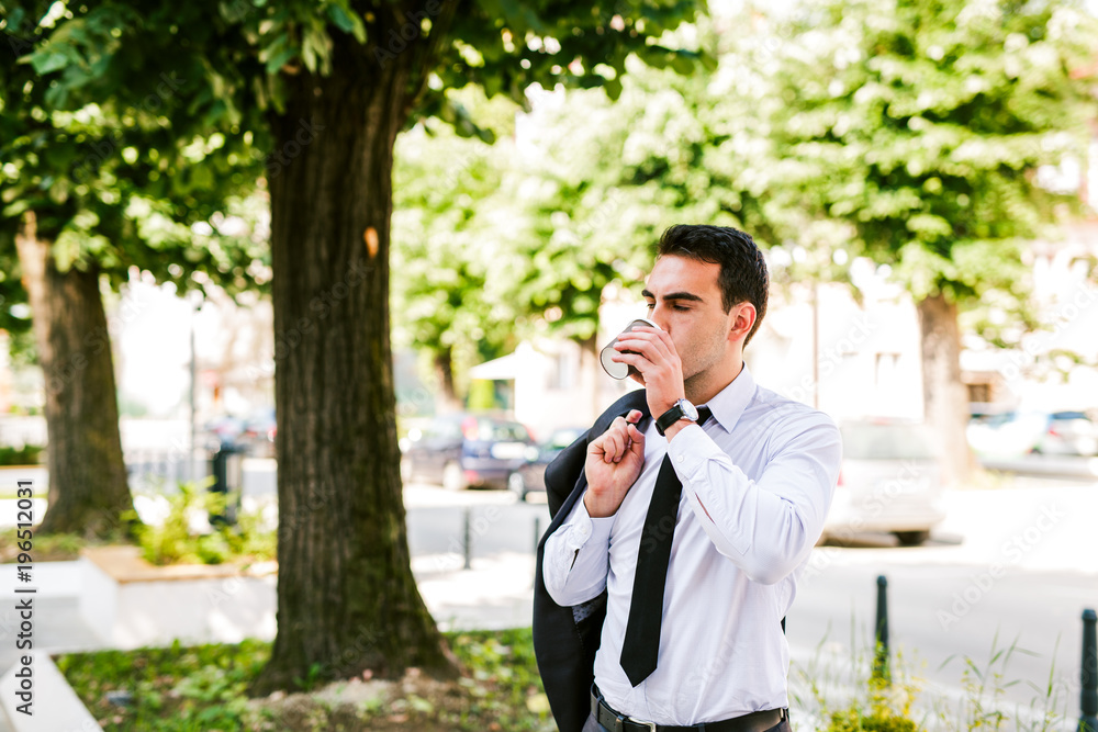 Young businessman take break to drink coffee at the avenue Young businessman take break to drink coffee at the avenue