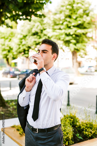 Young businessman take break to drink coffee at the avenue