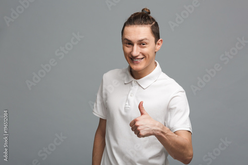Cheerful young man showing thumbs up.