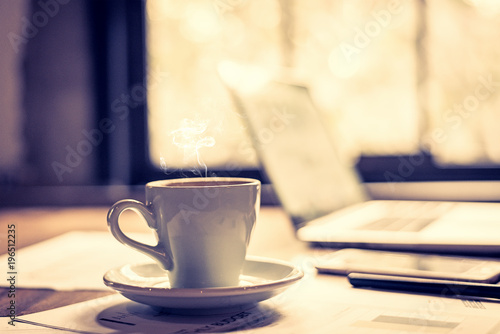 Closeup white cup of coffee break in the work space. Vintage Tone