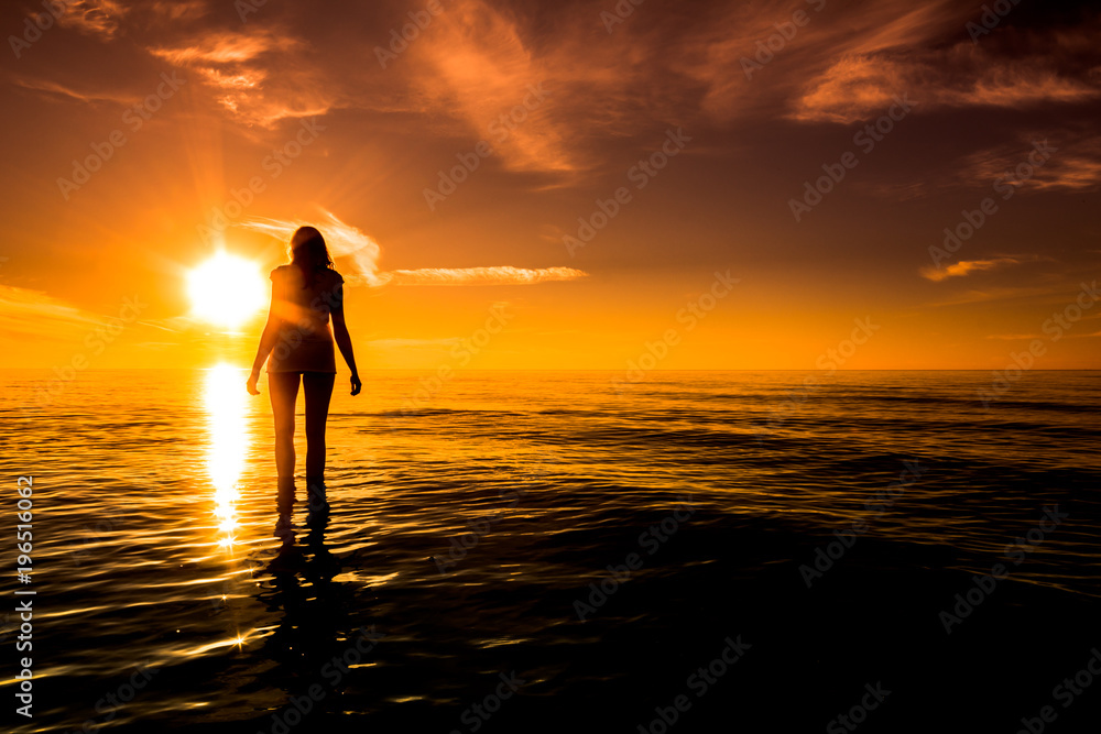 Sunset beach. Woman over sea in the sun, summer background, Baltic Sea, Poland