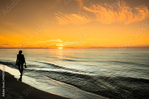 Silhouette of woman on sea sunset background, summer landscape, Poland