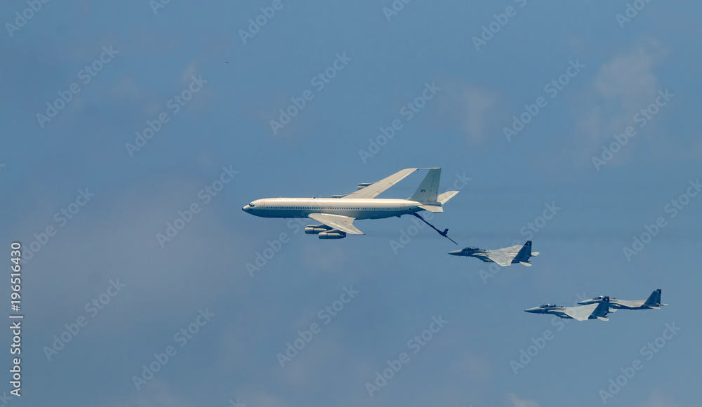 Fototapeta premium Izraelski myśliwiec i tankowiec podczas tankowania w powietrzu. Jets lecą od prawej do lewej w szyku.
