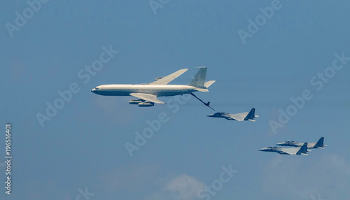 Israeli fighter jet and tanker in air refueling. The Jets flight from right to left in formation.
