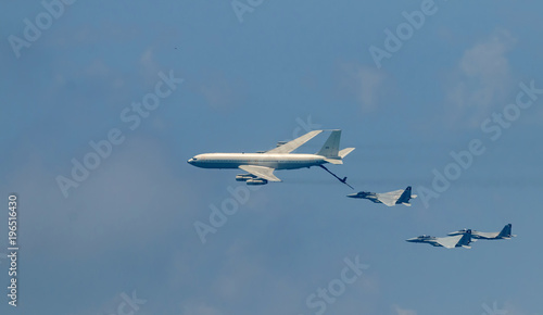 Israeli fighter jet and tanker in air refueling. The Jets flight from right to left in formation.