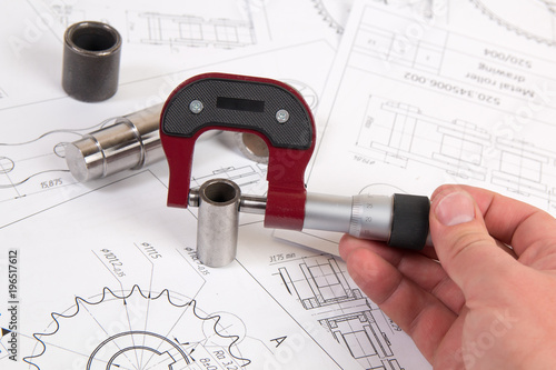 Technical drawing, micrometer and driving roller chain. Engineering, technology and metalworking. Micrometer measurement of detail of industrial chain. photo