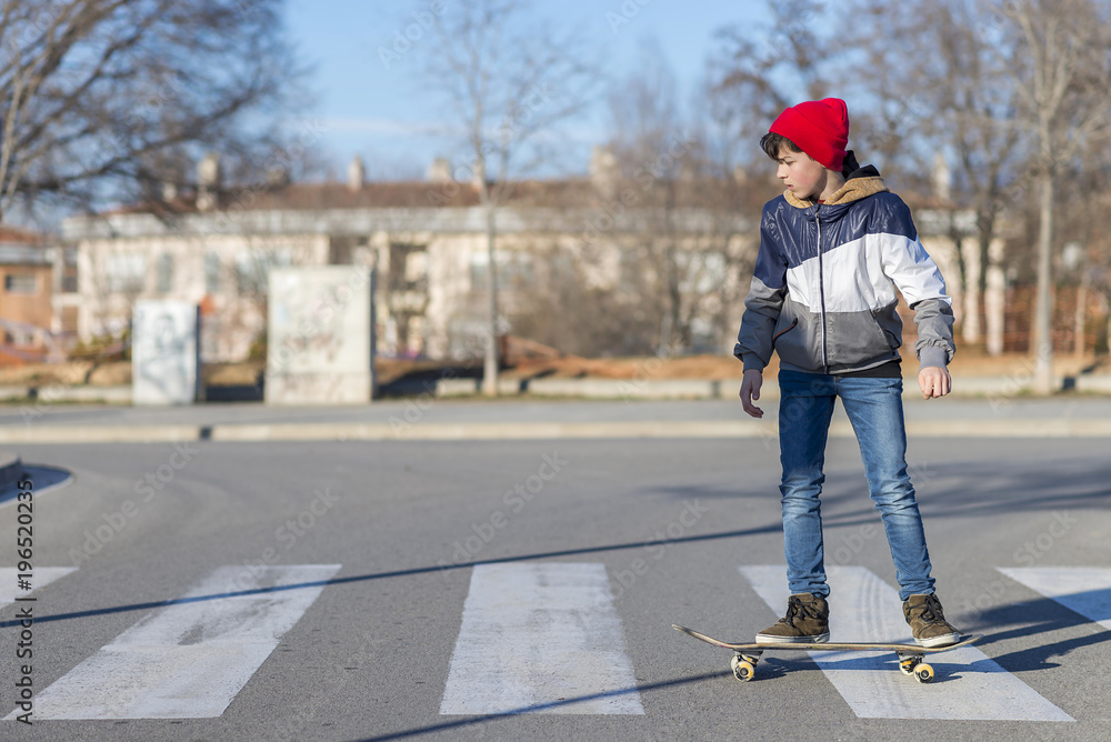 Skater-teenager wearing a hat boarding on the street Skater-teenager wearing a hat boarding on the street