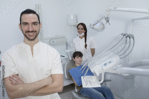 Fototapeta Naklejka Na Ścianę i Meble -  A portrait of a dentist with his team working in the background