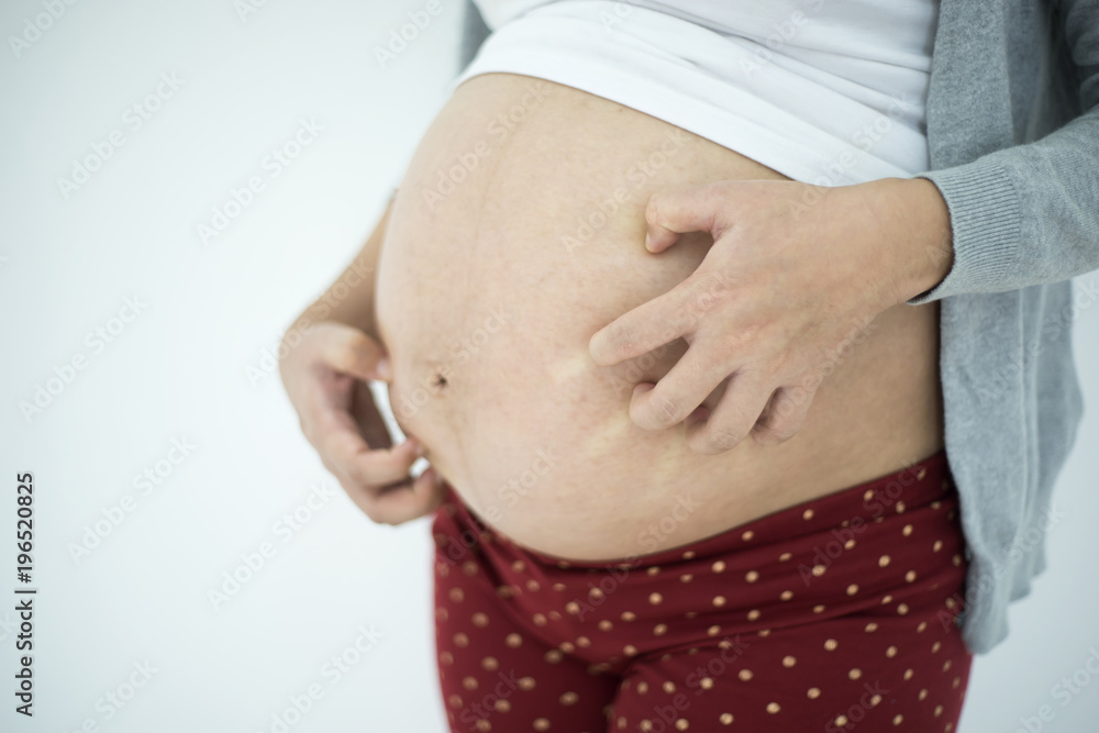 Pregnant woman scratching belly Pregnant woman scratching belly