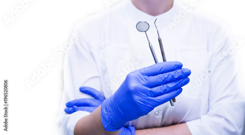 Gloved dentist hands holding dental instruments in medical dental clinic