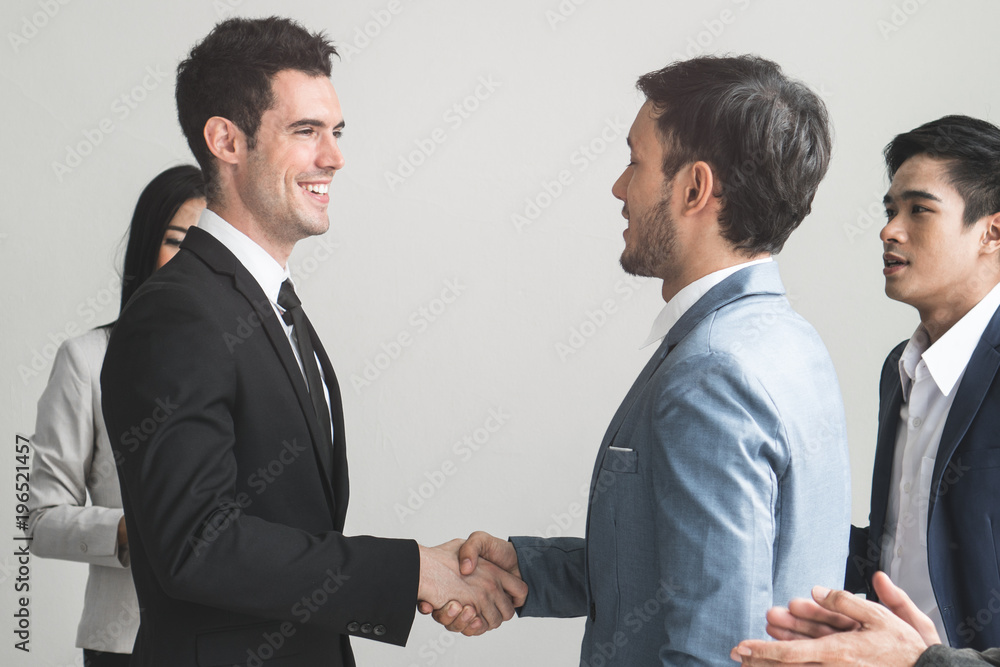 Business partner agreement success concept.Two businessmen shaking hands after seal a deal in the meeting and their staff team congratulation on background, Business partnership concept. Business partner agreement success concept.Two businessmen shaking hands after seal a deal in the meeting and their staff team congratulation on background, Business partnership concept.