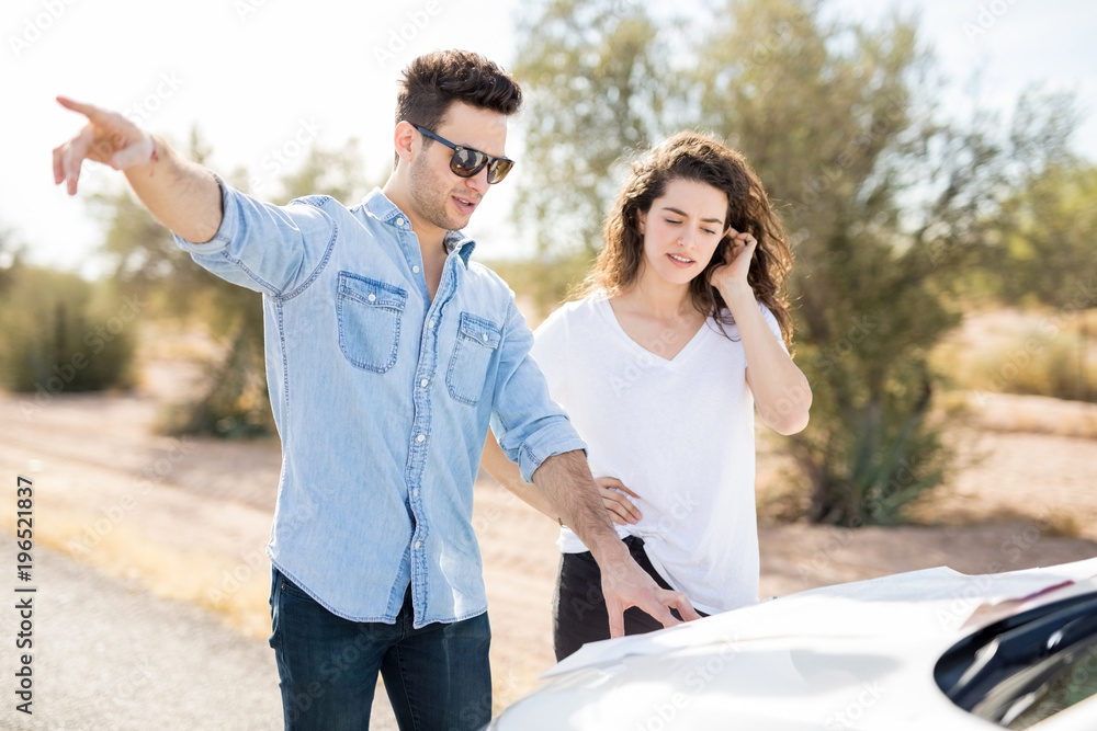 Couple trying to find a way from map Couple trying to find a way from map