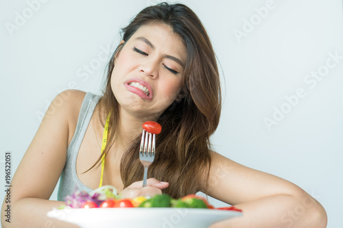 Fényképezés unhappy asian women is on dieting time looking at tomato on the fork