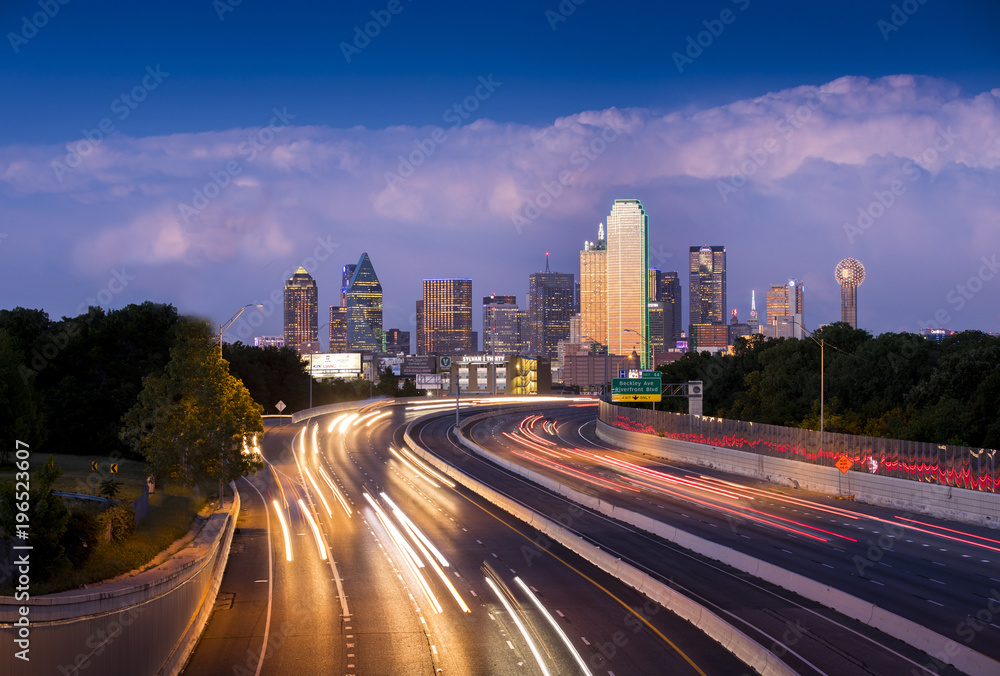 Long exposure of evening rush hour with cars racing in and out of Downtown Dallas, Texas on a stormy night.