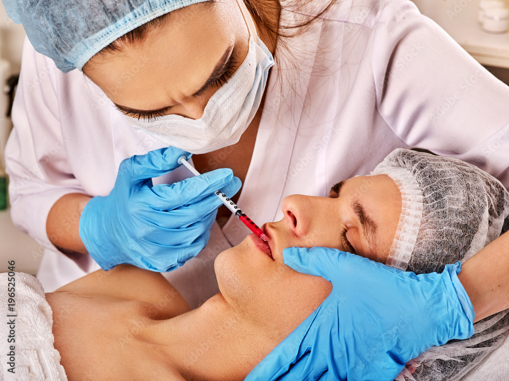 Filler injection for male forehead face. Plastic aesthetic facial surgery in beauty clinic. Bottox injections. Cropped shot of doctor in medical gloves with syringe injects nasolabial fold drug. Filler injection for male forehead face. Plastic aesthetic facial surgery in beauty clinic. Bottox injections. Cropped shot of doctor in medical gloves with syringe injects nasolabial fold drug.