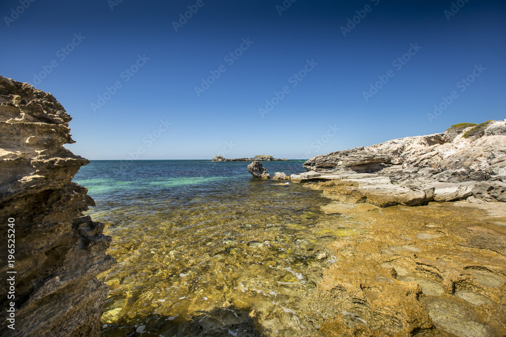 Perfectly clear water rolls upon the rocky coastline of Rottnest Island, near Perth in Western Australia.