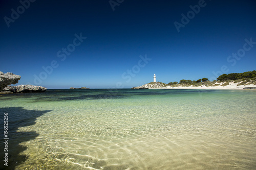 The Bathurst Lighthouse towers above the perfectly clear water rolling upon the white sand beaches of Rottnest Island  near Perth in Western Australia.