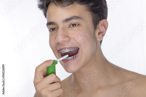 Teen boy wearing braces on white background photo