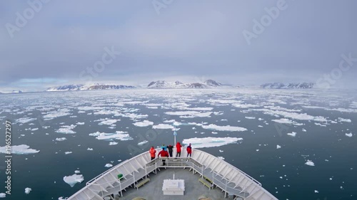 A POV time lapse shot of a ship bow, icebergs and tourists passing through Cape Fanshaw, Alaska. photo