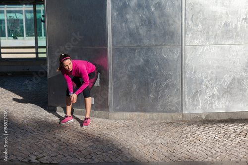 Young woman squatting against wall