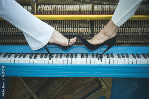 Canvas Print legs on piano keyboard blue color, fashion.
