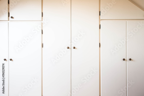 Many white closet doors retro style indoors in a house