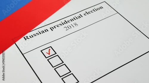 Concept of the 2018 Russian presidential election on 18 March 2018. Hand voting in a ballot by red pencil with national flag of Russia photo