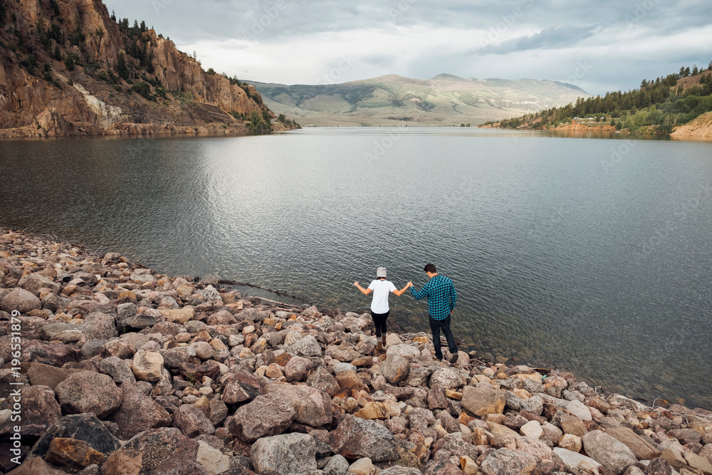 Couple walking on rocks beside Dillon Reservoir, elevated view, Silverthorne, Colorado, USA Couple walking on rocks beside Dillon Reservoir, elevated view, Silverthorne, Colorado, USA