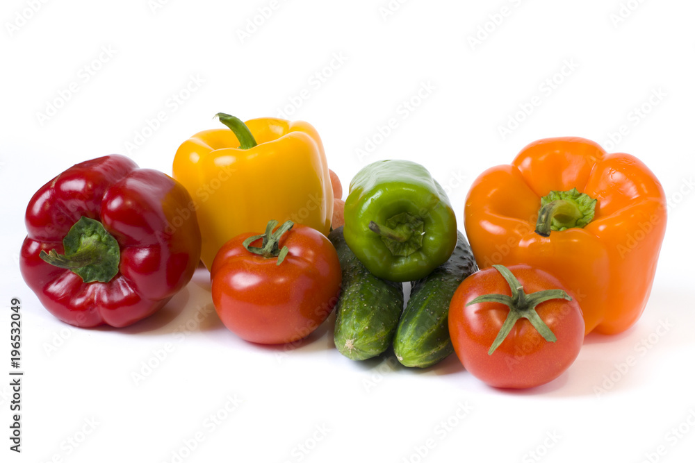 Red yellow and orange peppers with tomatoes on a white background. Cucumbers with colorful peppers in composition on a white background.. Red yellow and orange peppers with tomatoes on a white background. Cucumbers with colorful peppers in composition on a white background..