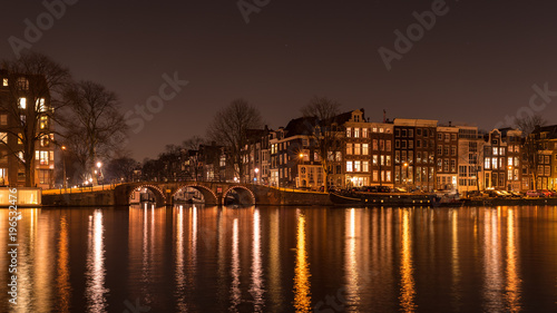 Canals of Amsterdam in the night with light in Amstel