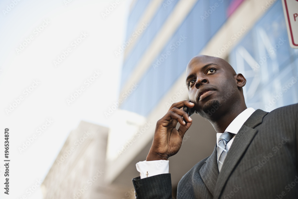 Low angle view of man talking on smartphone Low angle view of man talking on smartphone