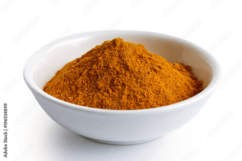 Turmeric powder in white ceramic bowl isolated on white. Turmeric powder in white ceramic bowl isolated on white.