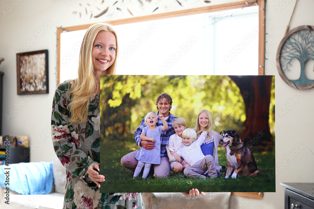 Happy Young Woman Holding Canvas Print of Family Portrait - obrazy, fototapety, plakaty 