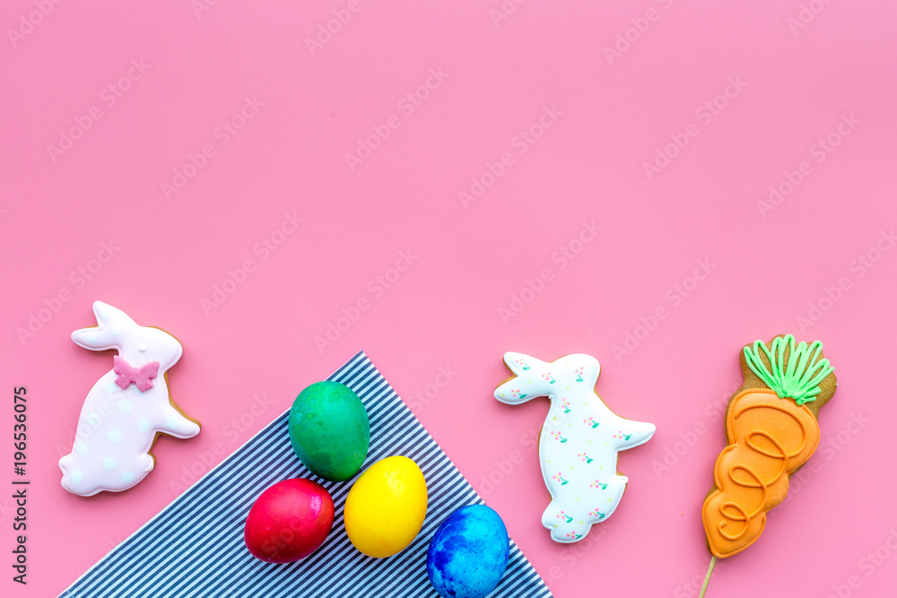 Sweets for celebrate Easter. Gingerbread in shape of easter bunny and easter eggs. Pink background top view copy space