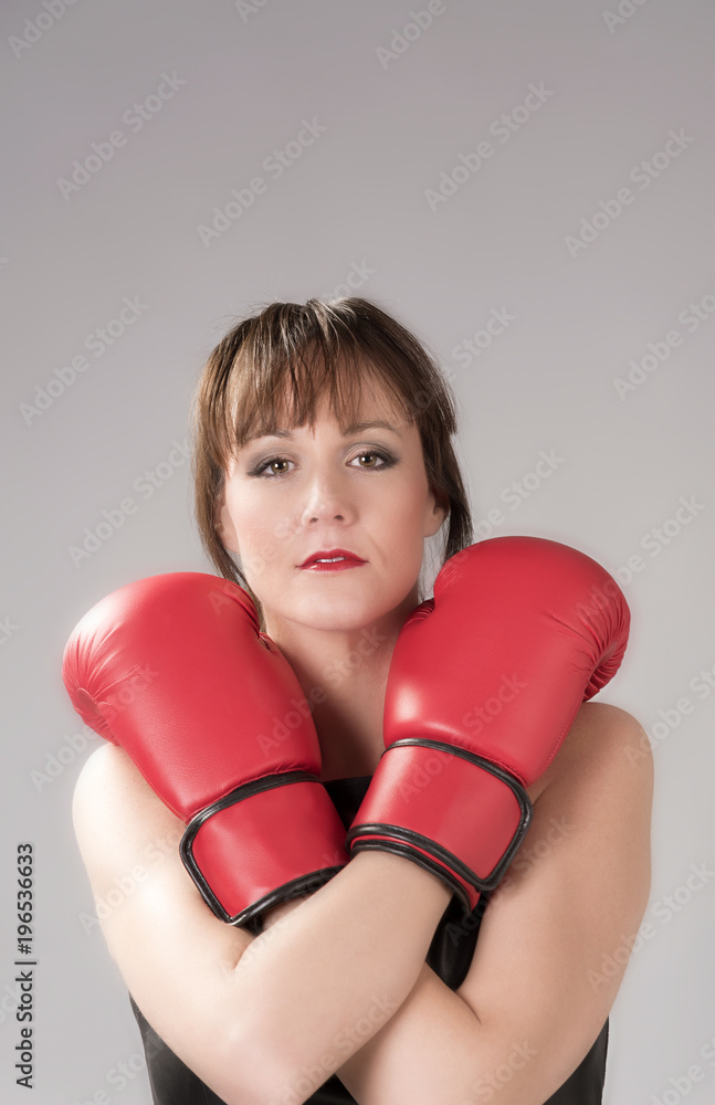 Woman wearing a black leather dress and re boxing gloves Woman wearing a black leather dress and re boxing gloves