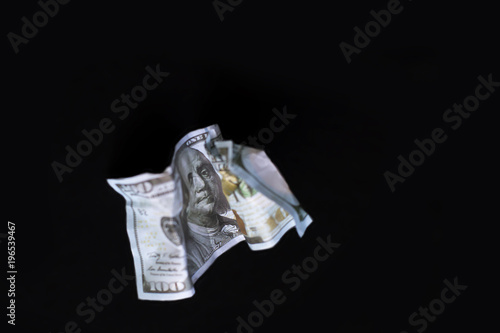 a crumpled dollar on the black background