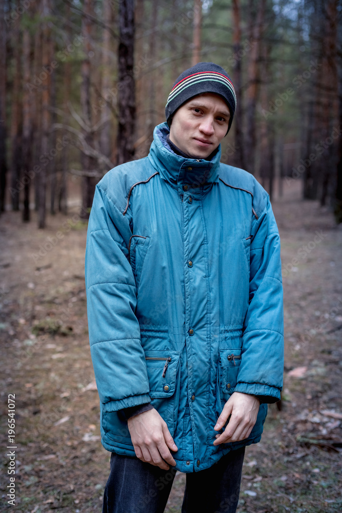 A rural guy posing in a pine forest in the autumn time. A rural guy posing in a pine forest in the autumn time.